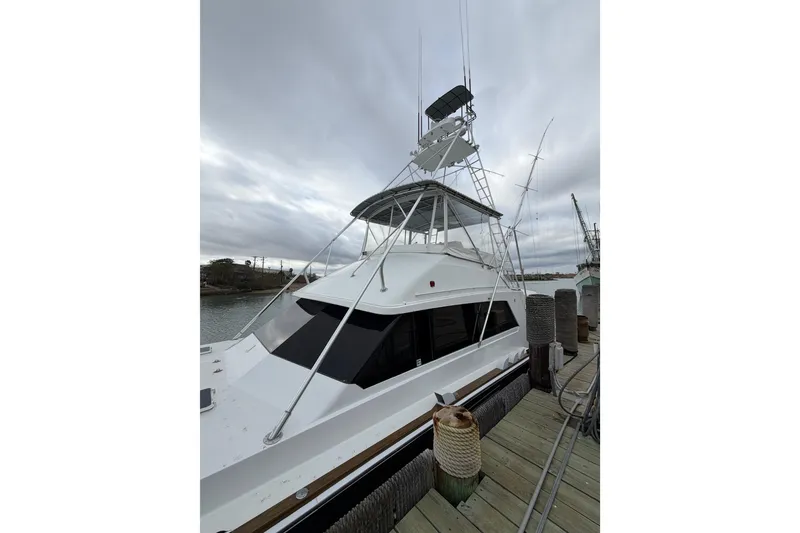 Slide: The Image of 1985 Bertram 54 Convertible yacht docked under cloudy skies. - 3