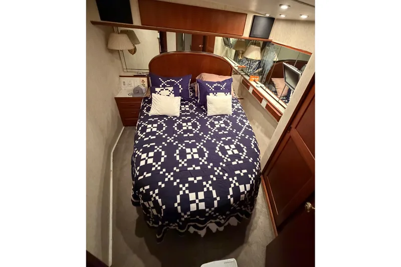 Slide: The Image of Cozy bedroom in 1985 Bertram 54 Convertible yacht with patterned bedding and wood accents. - 31