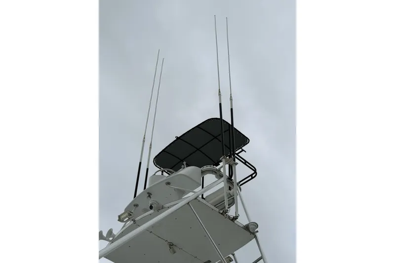 Slide: The Image of 1985 Bertram 54 Convertible boat tower with antennas against cloudy sky. - 8