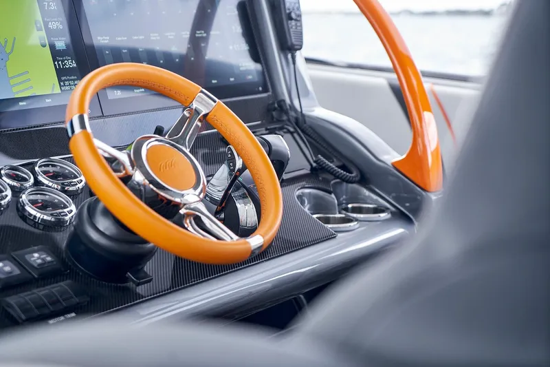 Slide: The Image of 2020 Midnight Express 43 Open boat dashboard with orange steering wheel and digital displays. - 105