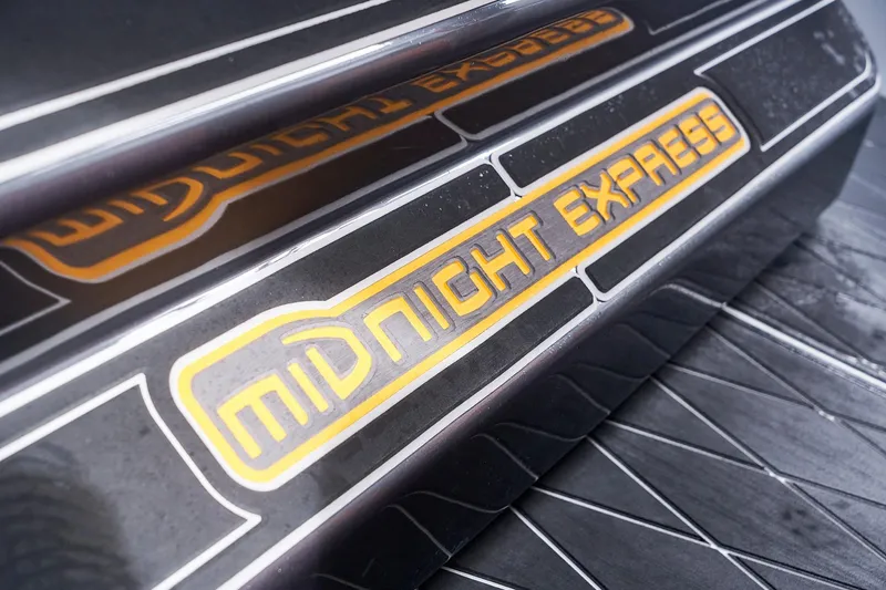 Slide: The Image of Midnight Express 43 Open 2020 logo on sleek black surface. - 112