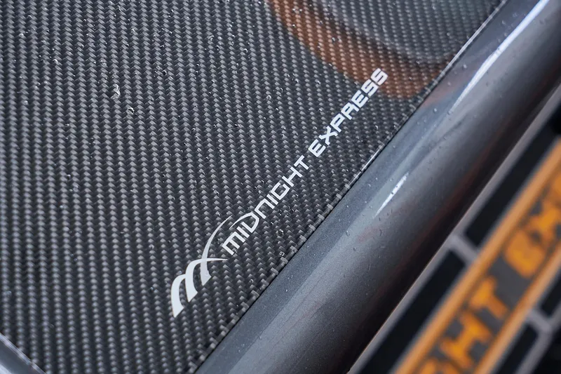 Slide: The Image of Close-up of 2020 Midnight Express 43 Open logo on carbon fiber surface. - 113