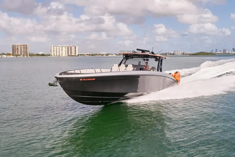 Slide: The Image of 2020 Midnight Express 43 Open boat cruising on a sunny day with city skyline in background. - 2