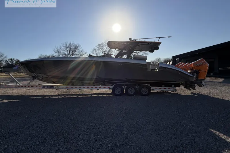 Slide: The Image of 2020 Midnight Express 43 Open boat on trailer, silhouetted against the sun. - 21