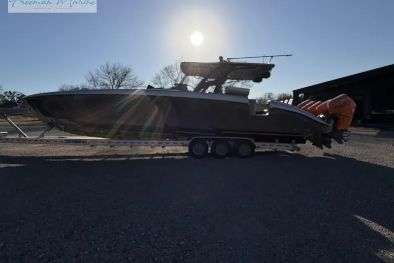Slide: The Image of 2020 Midnight Express 43 Open boat on trailer, silhouetted against the sun. - 22