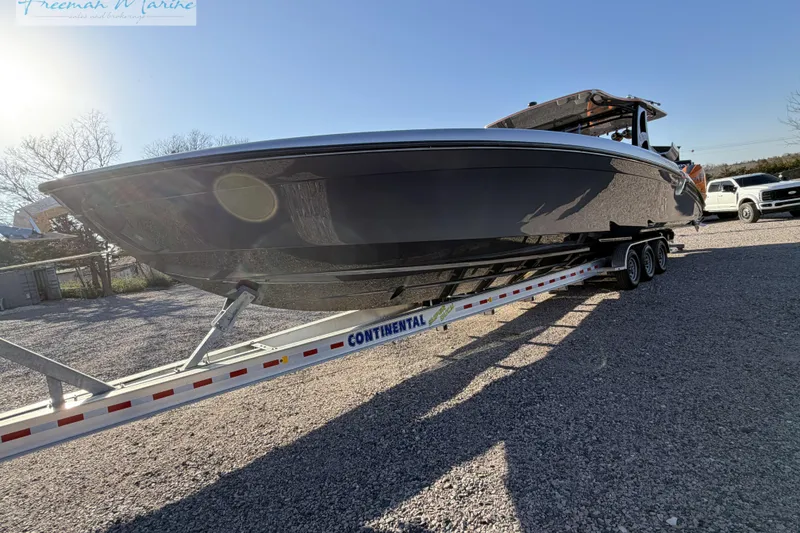 Slide: The Image of 2020 Midnight Express 43 Open boat on trailer in sunny outdoor setting. - 23