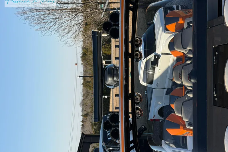 Slide: The Image of 2020 Midnight Express 43 Open boat with orange seats, parked near a white vehicle. - 70