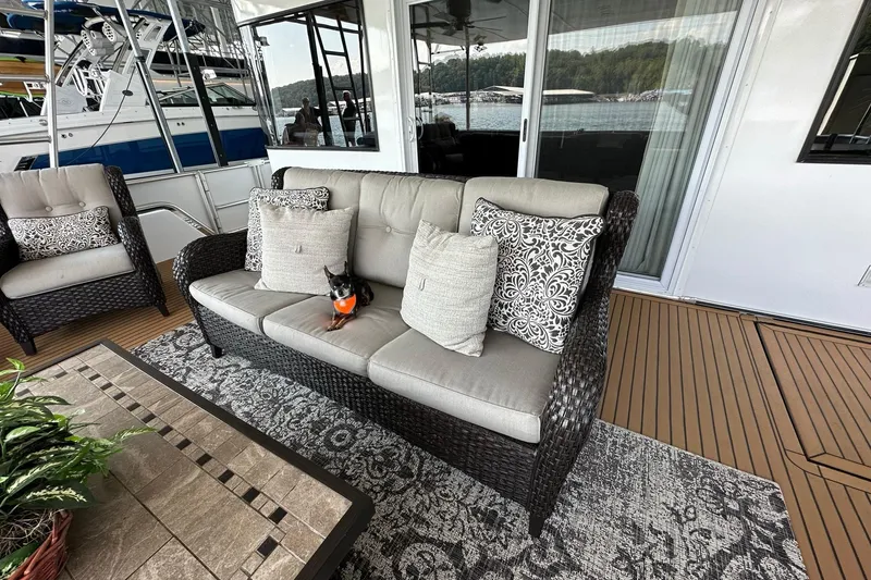 Slide: The Image of Outdoor seating area on 2022 Trifecta houseboat with wicker furniture and decorative pillows. - 10