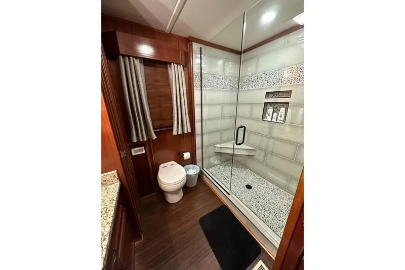 Slide: The Image of Luxurious 2022 Trifecta houseboat bathroom with glass shower, modern fixtures, and elegant wood accents. - 24