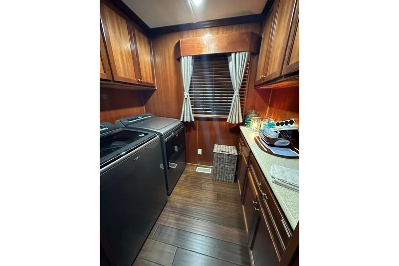 Slide: The Image of Laundry room in 2022 Trifecta houseboat with wooden cabinets and modern appliances. - 30