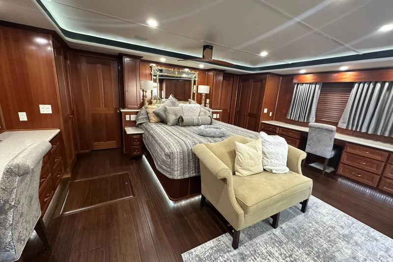 Slide: The Image of Luxurious 2022 Trifecta houseboat bedroom with elegant wood furnishings and cozy seating area. - 31
