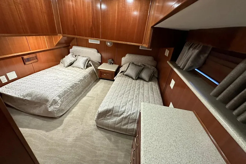 Slide: The Image of Luxurious 2022 Trifecta houseboat bedroom with twin beds and elegant wood paneling. - 33