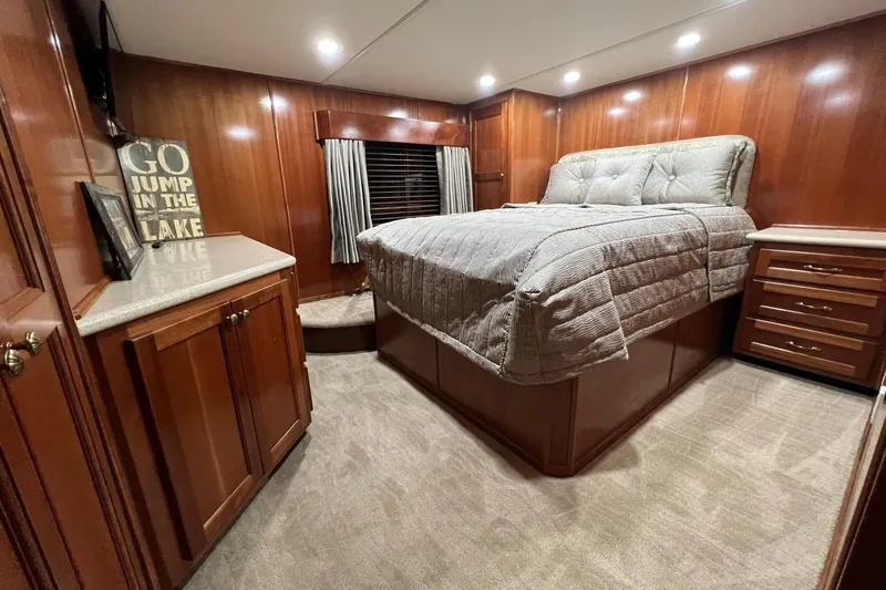 Slide: The Image of Luxurious 2022 Trifecta houseboat bedroom with wood paneling and cozy bed. - 39