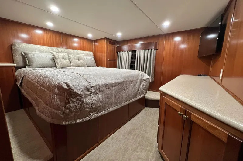 Slide: The Image of Luxurious 2022 Trifecta houseboat bedroom with wood paneling and cozy bedding. - 40