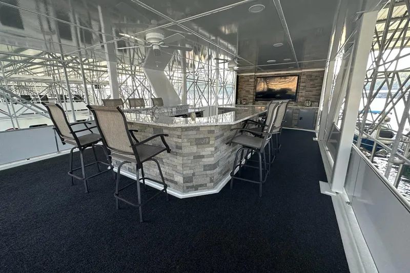 Slide: The Image of Luxurious 2022 Trifecta houseboat interior with bar, high chairs, and mounted TV. - 56