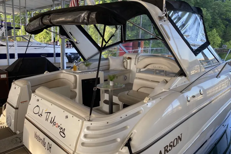 The Image of 2004 Larson Cabrio 330 boat docked, featuring a spacious seating area and canopy. - 0