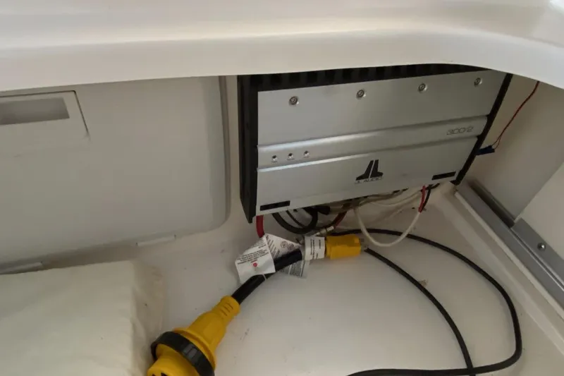 Slide: The Image of Electrical components inside a 2004 Larson Cabrio 330 boat, featuring wiring and connectors. - 23