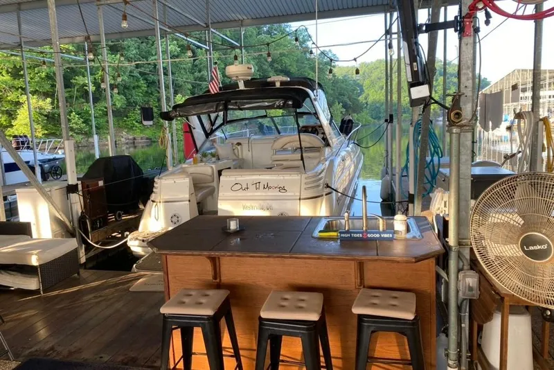 Slide: The Image of 2004 Larson Cabrio 330 docked in a covered marina with outdoor seating and fan. - 33