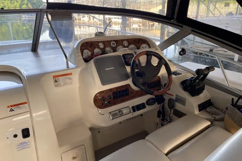 Slide: The Image of 2004 Larson Cabrio 330 boat cockpit with steering wheel and control panel. - 5