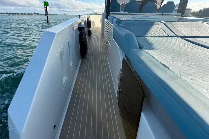 Slide: The Image of 2022 De Antonio Yachts 42 deck view with blue seating and ocean backdrop. - 62