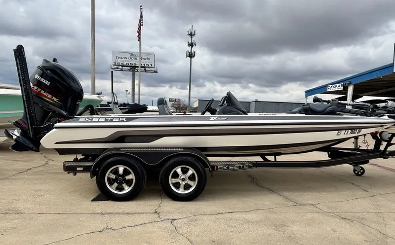 Slide: The Image of 2016 Skeeter ZX225 boat on trailer, Yamaha engine, cloudy sky. - 2