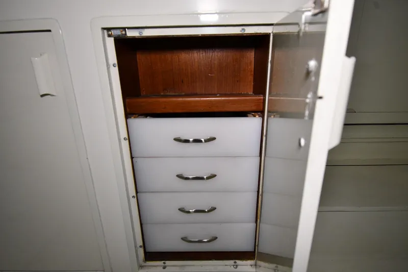 Slide: The Image of Open cabinet with four white drawers on a 1988 Viking 48 Convertible boat. - 13