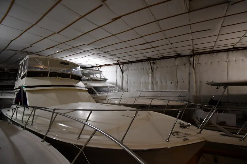 Slide: The Image of 1988 Viking 48 Convertible yacht stored indoors, surrounded by other boats. - 2