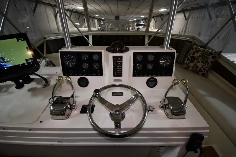 Slide: The Image of 1988 Viking 48 Convertible yacht helm with steering wheel and navigation controls. - 26