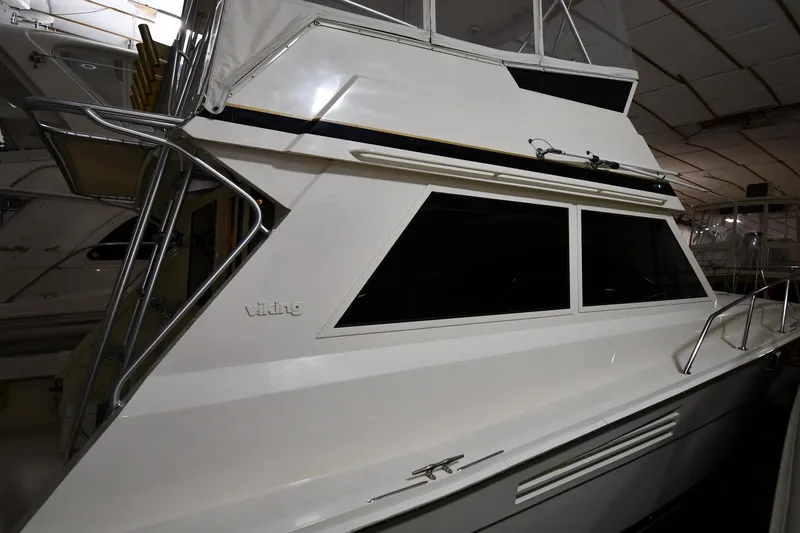 Slide: The Image of 1988 Viking 48 Convertible yacht in indoor storage, showcasing sleek design and windows. - 4
