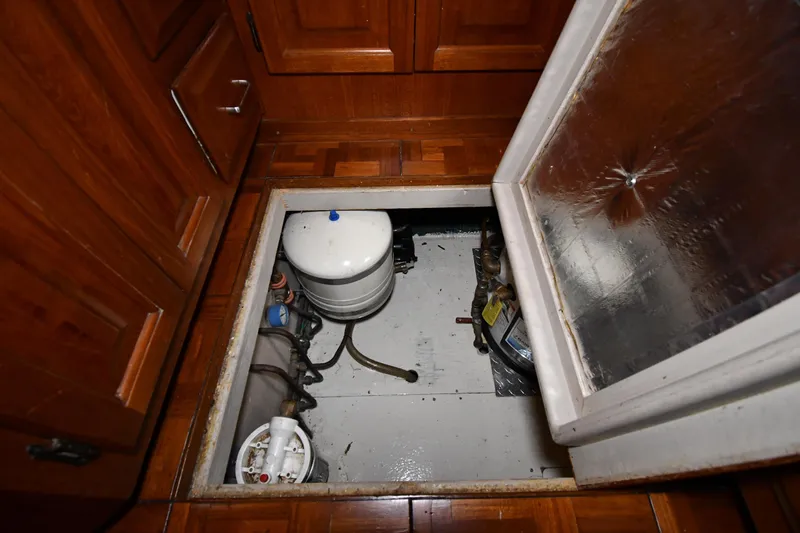 Slide: The Image of Engine compartment of 1988 Viking 48 Convertible boat with wooden flooring and equipment. - 60