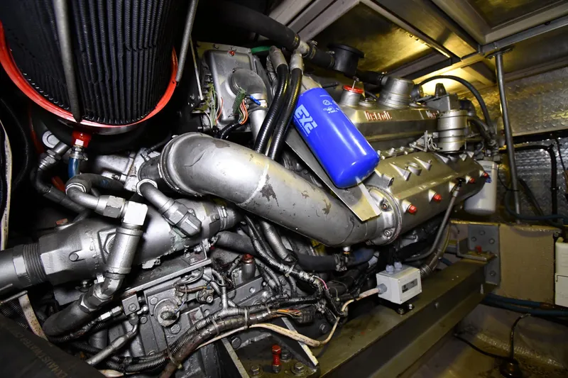 Slide: The Image of Engine room of a 1988 Viking 48 Convertible boat, showcasing complex machinery and components. - 70
