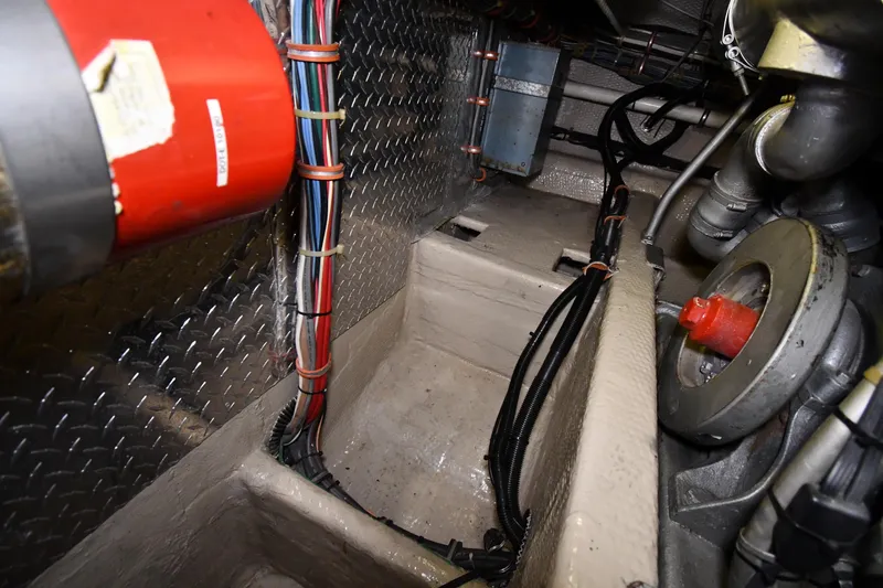 Slide: The Image of Engine room of 1988 Viking 48 Convertible boat, showing wiring and mechanical components. - 79