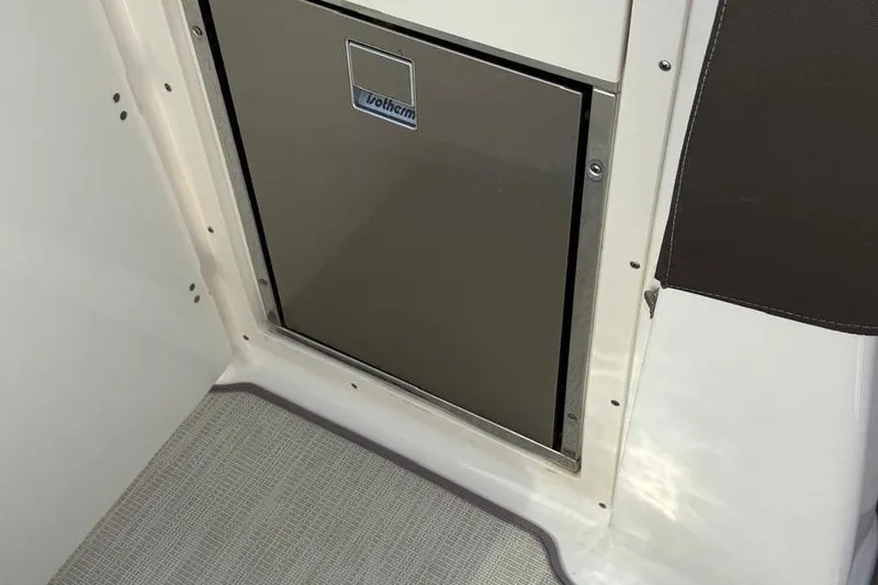 Slide: The Image of Built-in refrigerator on 2018 Chaparral 267 SSX boat interior. - 15