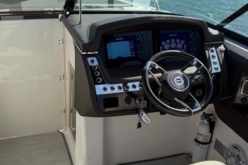 Slide: The Image of 2018 Chaparral 267 SSX boat dashboard with steering wheel and navigation screens. - 5