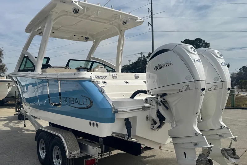 Slide: The Image of 2026 Robalo R257 Dual Console boat with twin Yamaha engines on a trailer. - 2