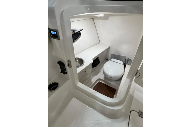 Slide: The Image of 2026 Robalo R257 Dual Console boat interior with compact bathroom amenities. - 5