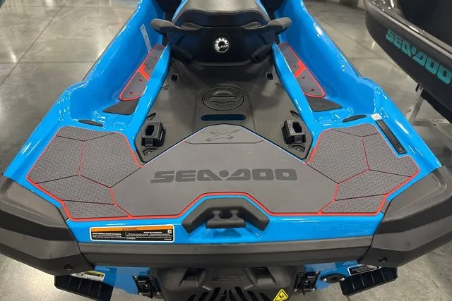 Slide: The Image of A blue Sea-Doo jet ski with gray and red accents, displayed in a showroom. - 12