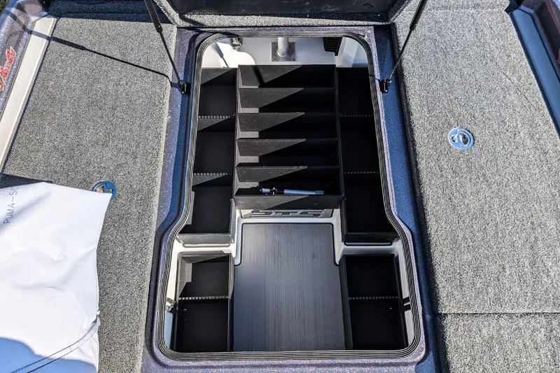 Slide: The Image of 2026 Bass Cat Lynx STS boat storage compartment with organized tackle box slots. - 17