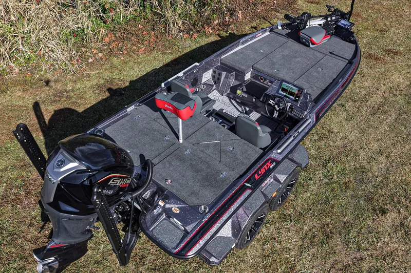 Slide: The Image of 2026 Bass Cat Lynx STS fishing boat with advanced features on grassy terrain. - 18