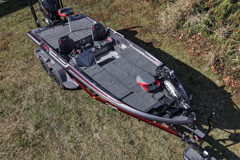Slide: The Image of 2026 Bass Cat Lynx STS fishing boat on grass, showcasing sleek design and spacious deck. - 19