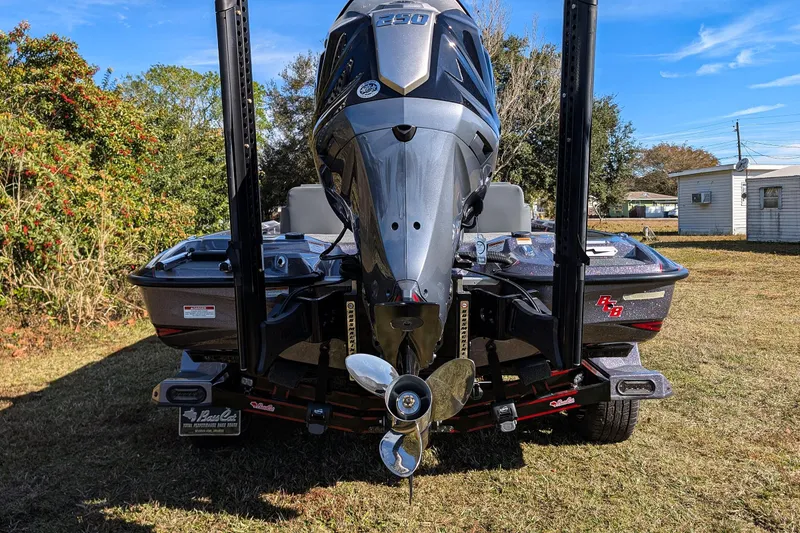 Slide: The Image of 2026 Bass Cat Lynx STS boat with powerful engine, parked on grass. - 8