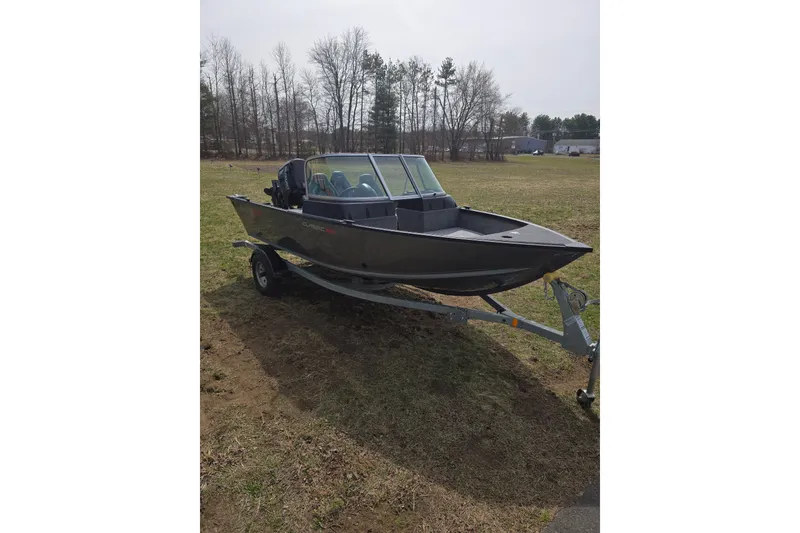 Slide: The Image of 2026 Alumacraft Classic 165 Sport boat on trailer in grassy area. - 3