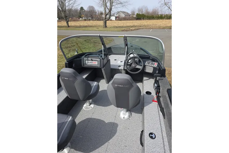 Slide: The Image of 2026 Alumacraft Classic 165 Sport boat interior with dual seats and steering console. - 5