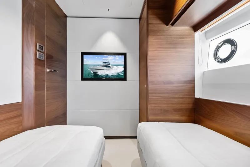 Slide: The Image of Luxurious 2024 Princess Y72 Motor Yacht cabin with twin beds and a wall-mounted TV. - 38