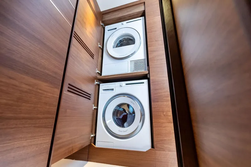 Slide: The Image of Stacked washer and dryer in 2024 Princess Y72 Motor Yacht's wooden cabinet. - 44