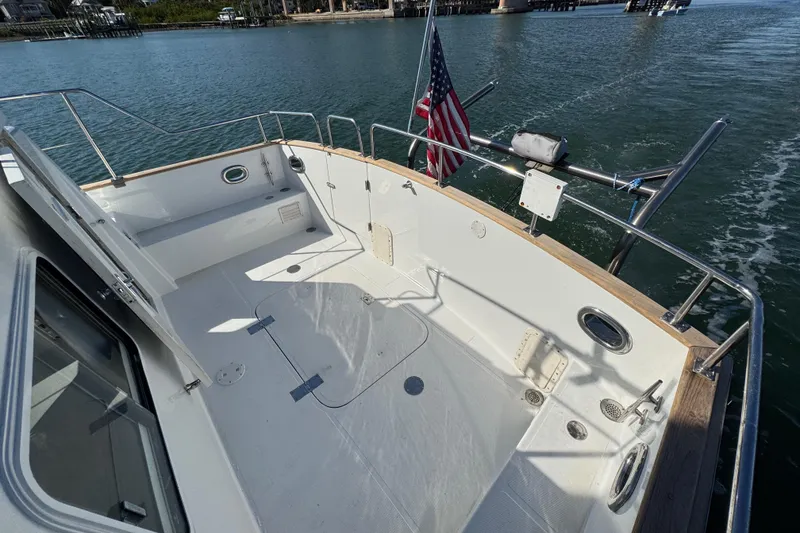 Slide: The Image of 2006 Albin 40 North Sea Cutter deck with American flag, cruising on calm waters. - 22
