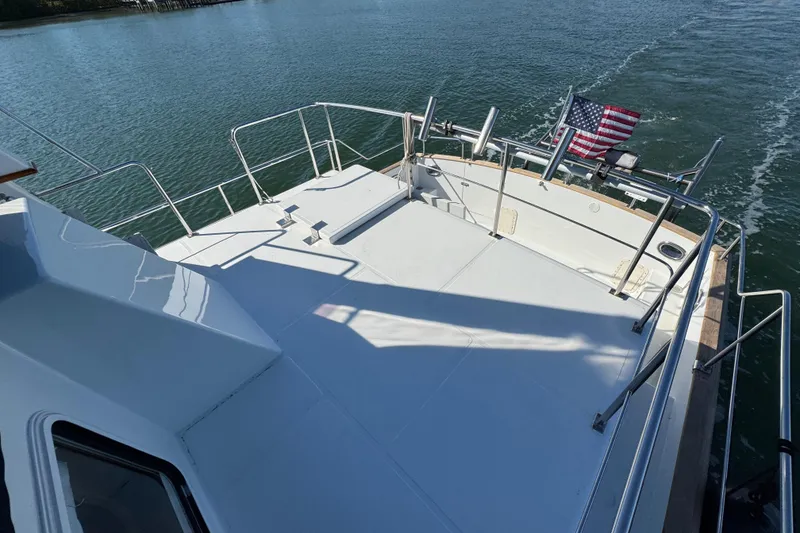 Slide: The Image of 2006 Albin 40 North Sea Cutter deck with railing and American flag on water. - 23