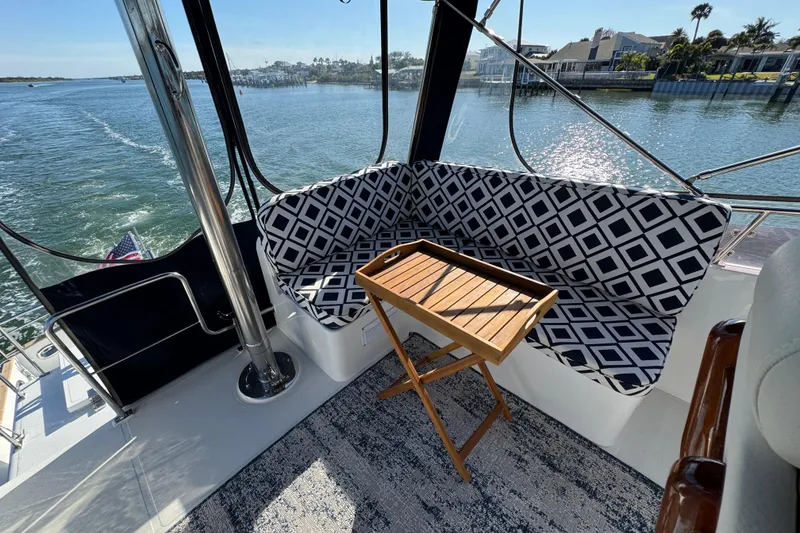 Slide: The Image of 2006 Albin 40 North Sea Cutter interior with patterned seating and wooden table, overlooking water. - 39