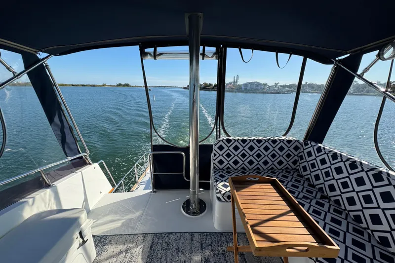 Slide: The Image of 2006 Albin 40 North Sea Cutter interior with patterned seating and wooden table on calm water. - 40