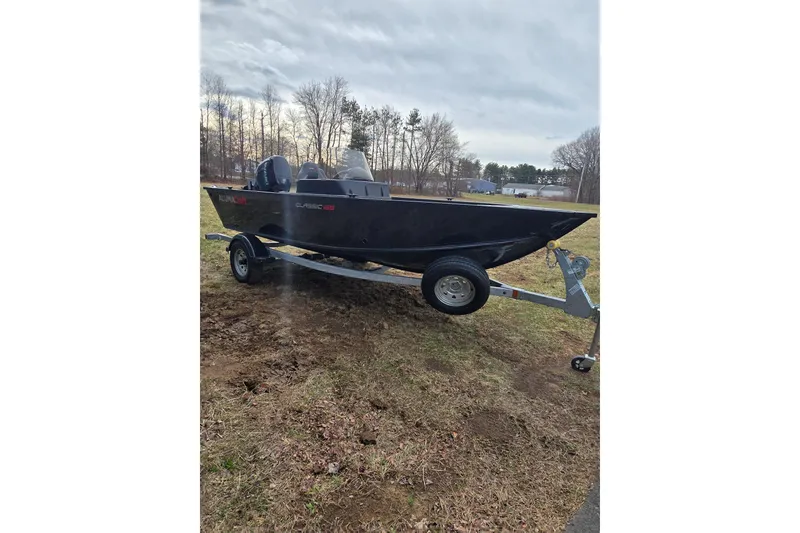 Slide: The Image of 2026 Alumacraft Classic 165 CS boat on trailer, parked on grassy area. - 8
